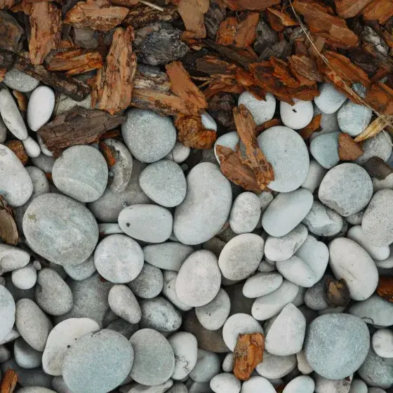 Gray landscape stones beside brown bark mulch